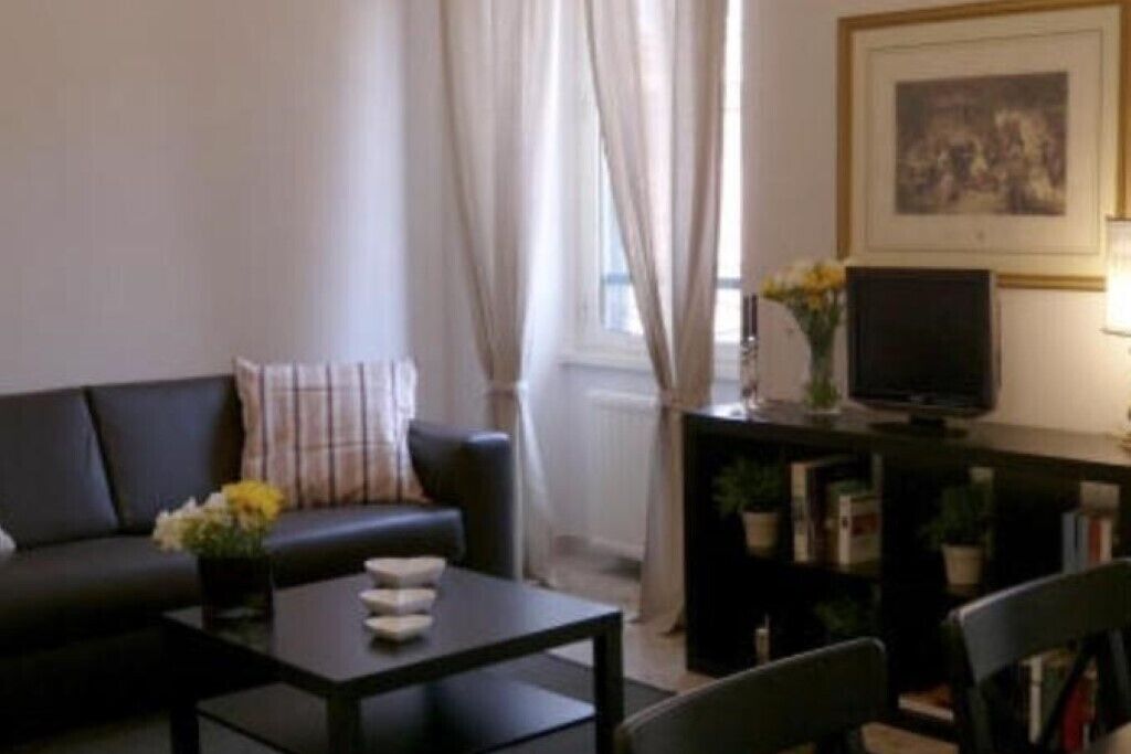 A living room with a sofa, a coffee table, a TV, and a bookshelf.