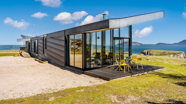A modern house with large glass windows, a deck, and a view of the sea. - Tuath na Mara - Three Bedroom Villa, Sleeps 9 (Doagh Beg)