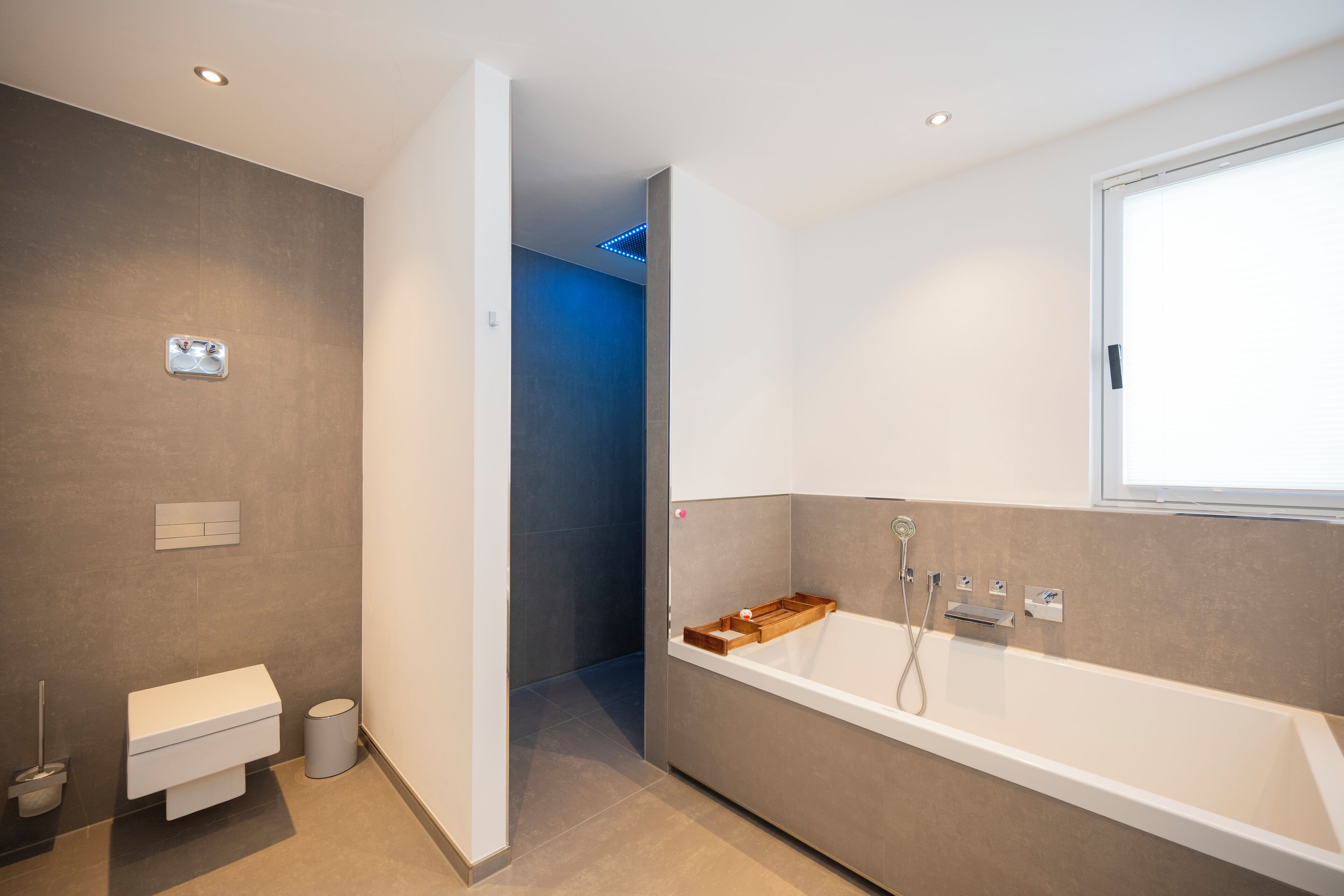 Ein modernes Badezimmer mit Badewanne, Toilette und Duschbereich.