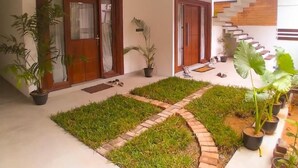A modern house with a spacious patio, a brick pathway, and potted plants. - Room in Villa - Surf 247 Weligama Hotel (Weligama)