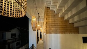 A corridor with a staircase, wicker lamps, and a brick wall. - Room in Villa - Surf 247 Weligama Hotel (Weligama)