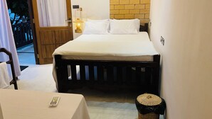 Une chambre à coucher avec un lit, une table de chevet, une lampe et un panier en osier.