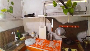 Une cuisine de taille réduite, équipée des éléments essentiels, notamment un évier, une cuisinière et un petit plan de travail.