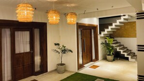 Un intérieur moderne avec un escalier, des portes en bois et des luminaires suspendus.