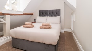 Una camera da letto con un letto grande, una testiera e una finestra.
