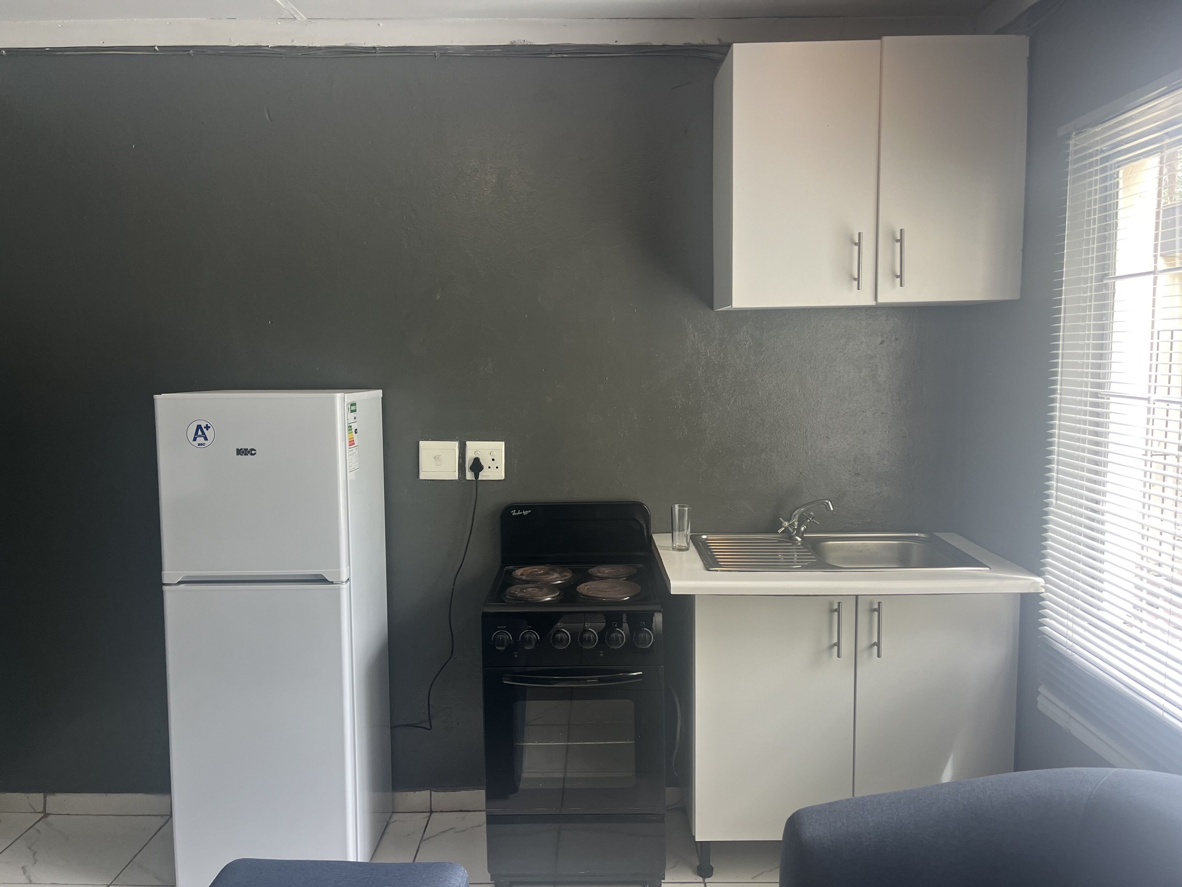 Una cocina compacta equipada con refrigerador, estufa y lavaplatos.