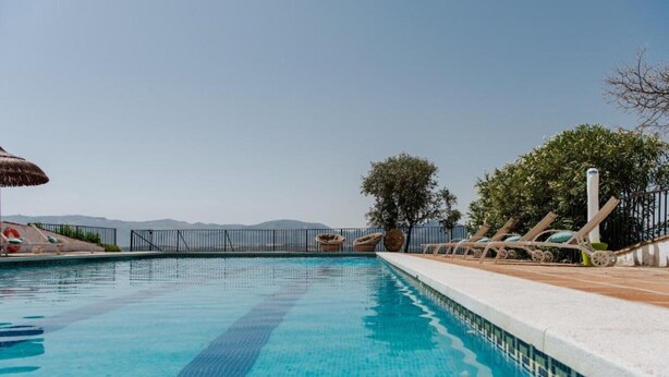 A swimming pool with lounge chairs and a view of the mountains. - Finca El Almendrillo (AN)