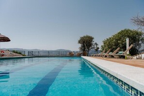 Une piscine dotée de chaises longues et offrant une vue sur les montagnes.