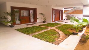 A modern house with a central courtyard, wooden doors, and potted plants. - Room in Villa - Surf 247 Weligama,sri Lanka (Weligama)