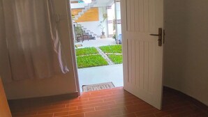 A room with a bed, a door leading to a balcony, and a view of a garden. - Room in Villa - Surf 247 Weligama,sri Lanka (Weligama)
