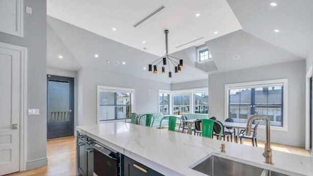 A modern kitchen with a large island, built-in appliances, and ample natural light from large windows. - Villa Paraiso (Long Beach)