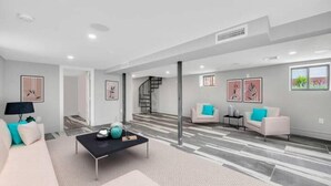 A modern living room with a sofa, coffee table, and artwork on the walls. - Villa Paraiso (Long Beach)