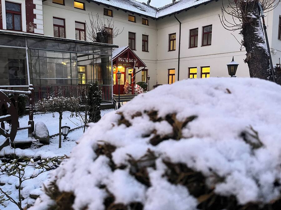 Un patio cubierto de nieve con un edificio que tiene múltiples ventanas y una entrada visible.
