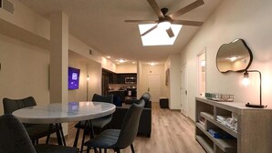 A modern kitchen with dark cabinetry and a microwave. - Suites  On  Mass  -  C3 (Lawrence)