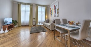 Relax in this stylish living room with a flat-screen TV, sofa, and dining area.