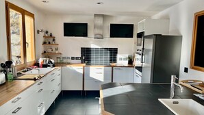 Una cocina moderna con armarios blancos, encimera negra y horno empotrado.
