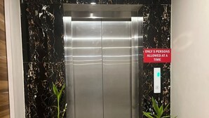 Un ascensor con un cartel que indica un límite de 5 personas por viaje.