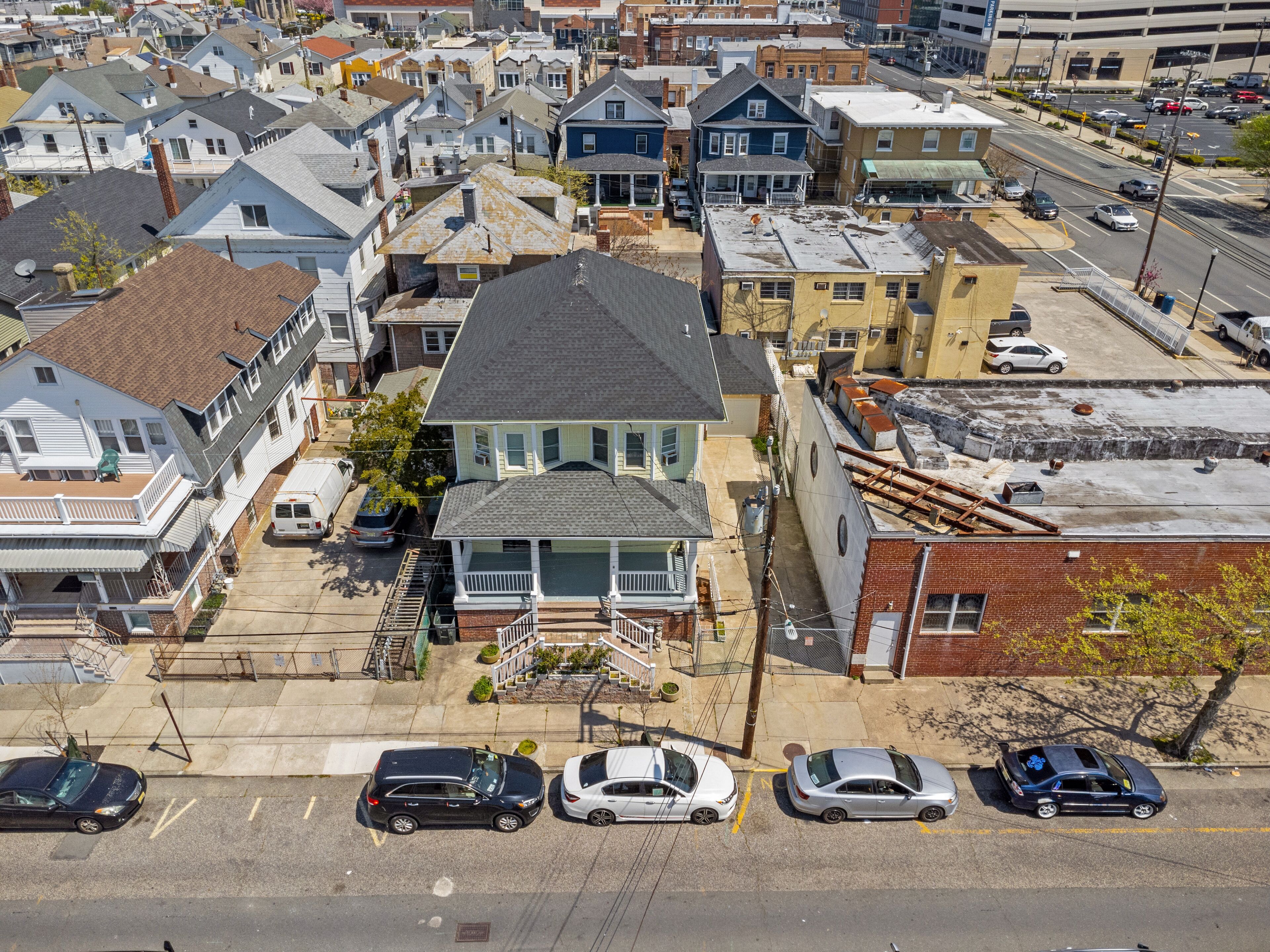 An aerial view of a residential area with houses, a parking lot, and a road.