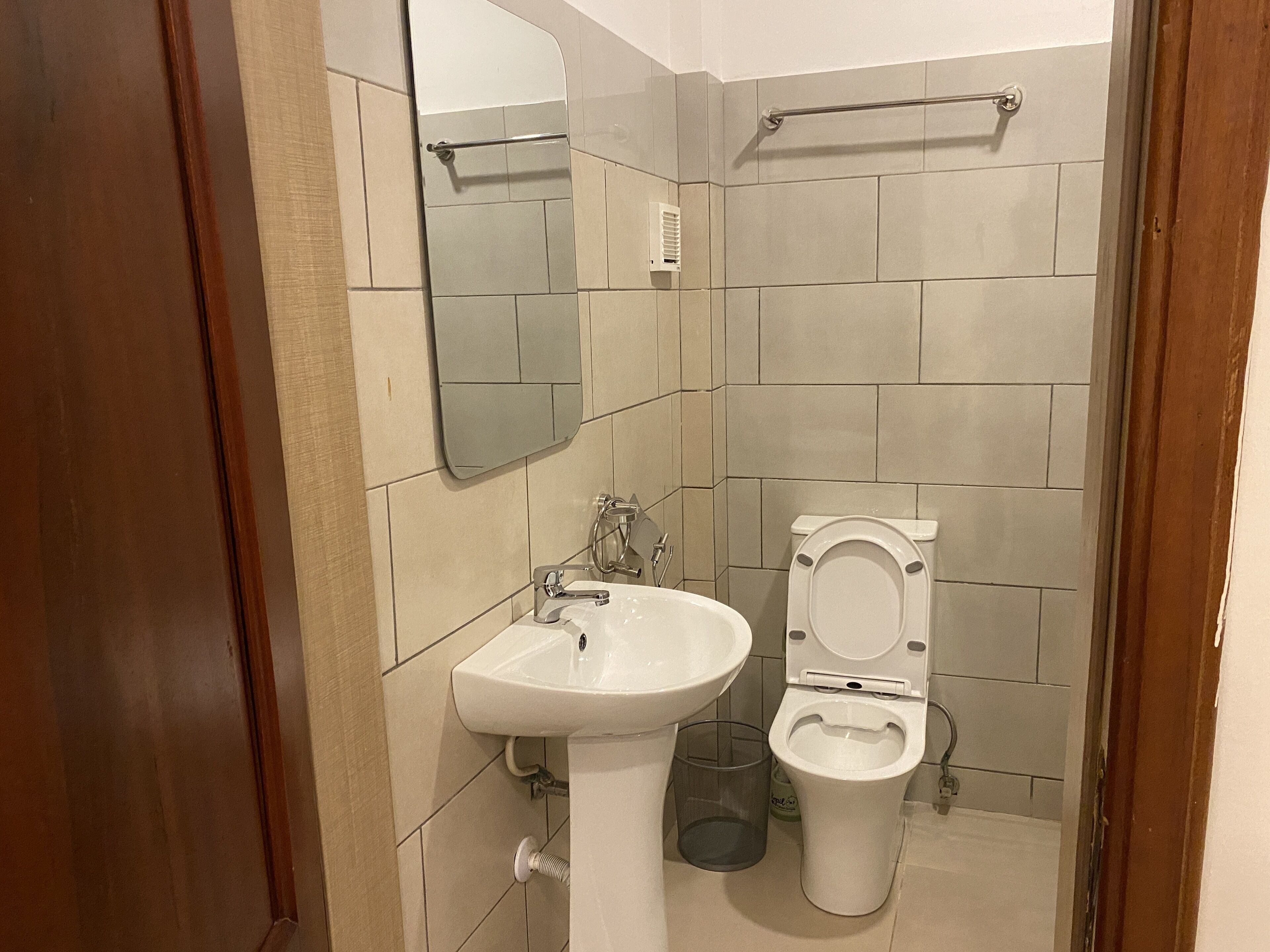 Un bagno con lavandino, wc e specchio.