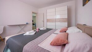 Una habitación de hotel con una cama, una mesita de noche, una silla y un espejo grande.