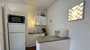 Een kleine keuken met een magnetron, een broodrooster en een spoelbak.