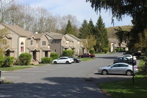 A residential street with houses, parked cars, and trees. - Family and pet-friendly, 2 Bedroom, 2 Bath, private townhome with wood-burning fireplace and jacuzzi tub (East Stroudsburg)