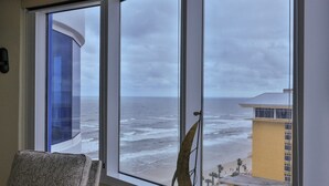 Una habitación con un ventanal grande con vista a una playa y al océano.