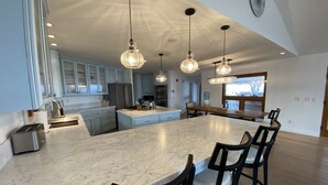A spacious kitchen with a large island, modern appliances, and pendant lighting.