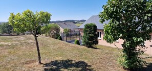 A residential area with a house, a fenced yard, and a clear sky. - Gîte du Puech 2-3 personnes (RIEUTORT DE RANDON)