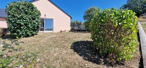 A residential property with a large garden, a house with a sliding glass door, and a clear blue sky. - Gîte du Puech 2-3 personnes (RIEUTORT DE RANDON)