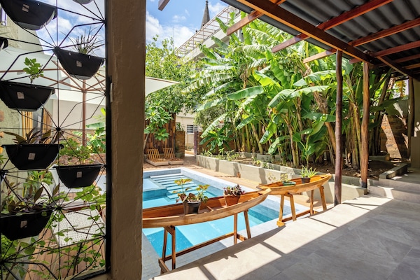 Una piscina al aire libre, sombrillas, sillones reclinables de piscina