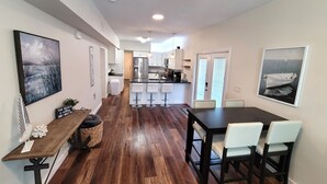 Una cucina moderna con isola centrale, sgabelli da bar e un tavolo da pranzo con sedie.