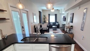 Una cucina moderna con una grande isola, mobili bianchi e una lavastoviglie in acciaio inossidabile.