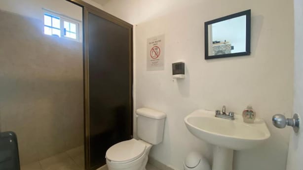 Ein Badezimmer mit Toilette, Waschbecken und Spiegel.