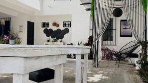 Un intérieur moderne avec une table blanche, des rideaux à rayures noires et blanches et une chaise noire.