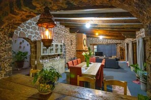 Cozy dining area with a stone archway, wooden table, and comfortable seating.