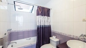 A bathroom with a bathtub, toilet, and sink. - InkaHuset Airport (Callao)