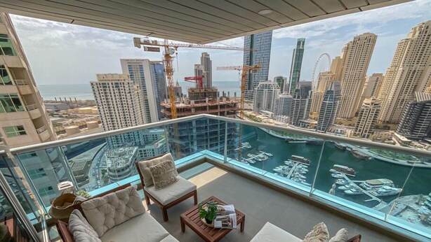 A high-rise apartment with a glass balcony overlooking a marina and city skyline. - Full Marina view - Opal Tower (Dubai)
