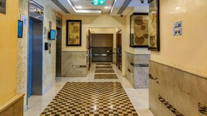 A hotel corridor with a checkered floor, marble walls, and an elevator. - Full Marina view - Opal Tower (Dubai)