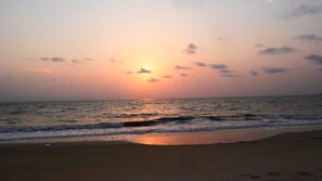 A beach with a sunset over the ocean.