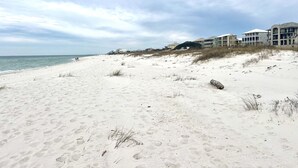 Una playa con orilla arenosa, algunos edificios al fondo y el océano.