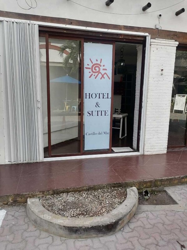 L’entrée d’un hôtel, avec une enseigne indiquant « HÔTEL & SUITE » et « Castillo del Mar ».