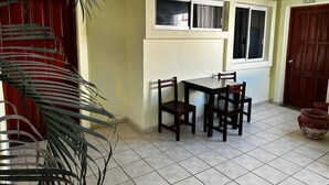 A dining area with a table and chairs, a window, and a door.