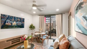 A modern living room with a sofa, a coffee table, and a TV mounted on the wall.