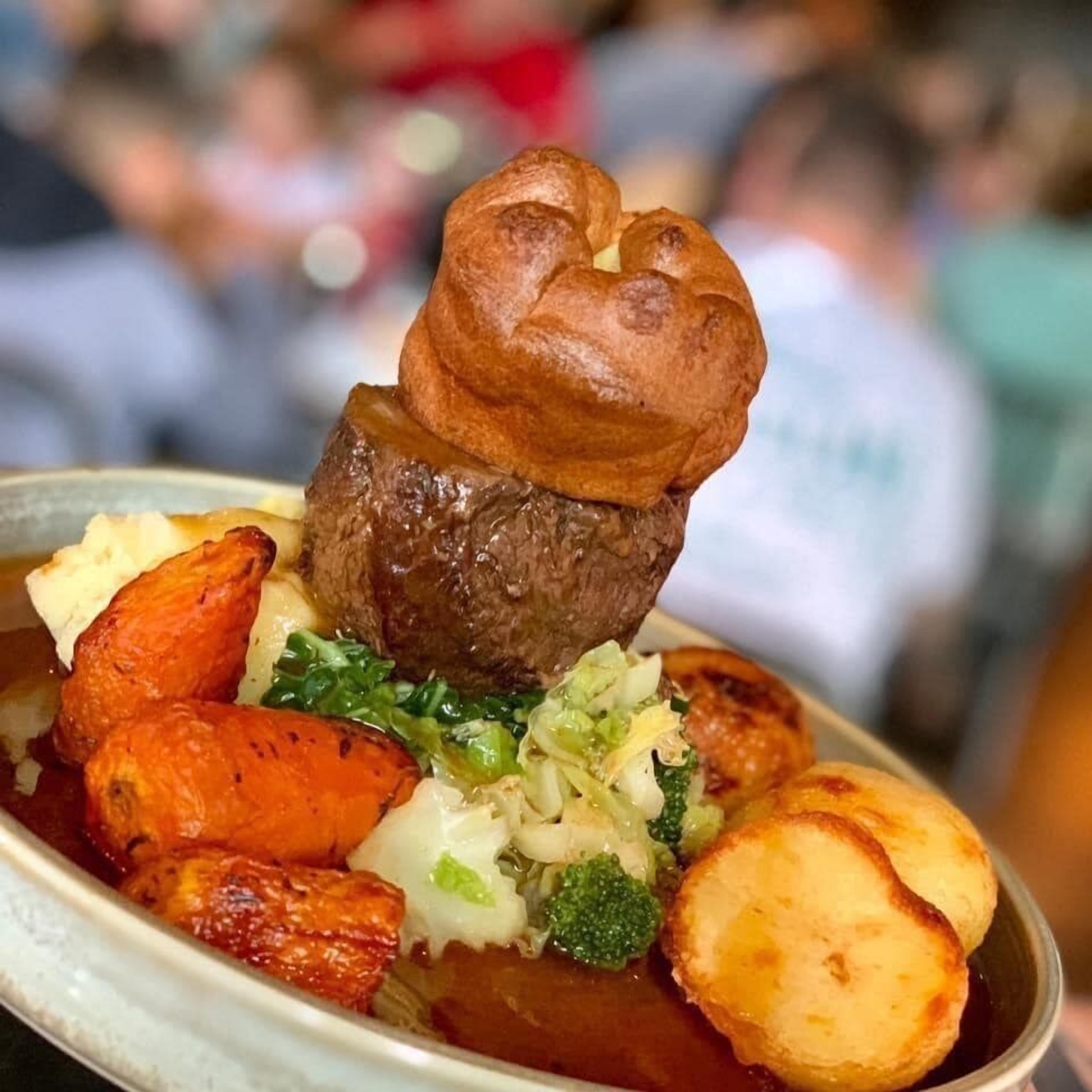A dish with beef, roasted potatoes, and vegetables.