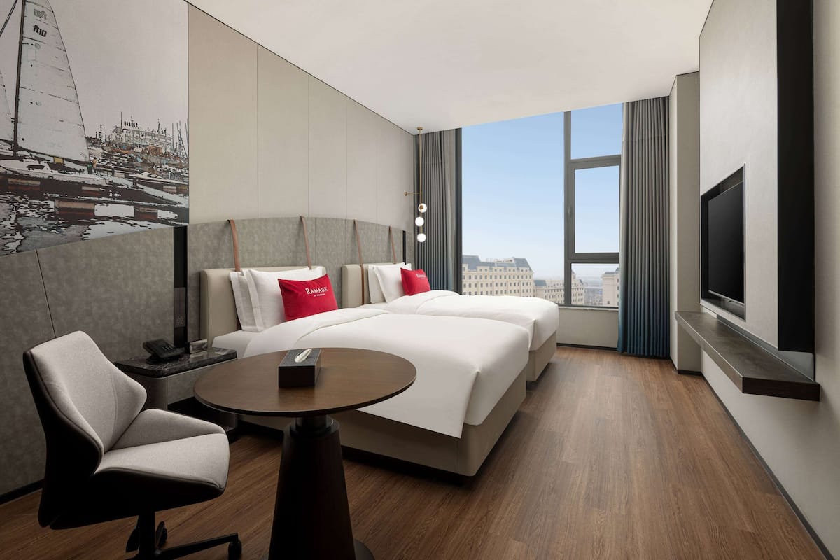 Une chambre d’hôtel moderne équipée d’un grand lit, d’un bureau, d’une chaise et d’une télévision.