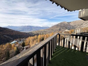 A balcony with a view of a valley and mountains.