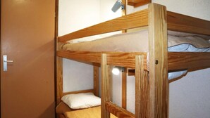 Een stapelbed met een deur aan de linkerkant en een lamp erboven.