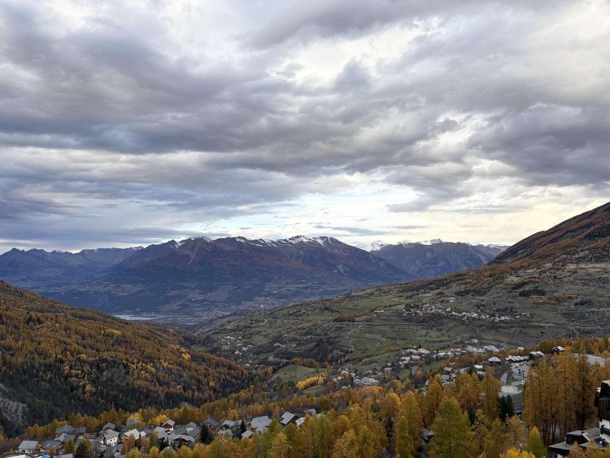 A mountainous landscape with a valley and a small settlement.