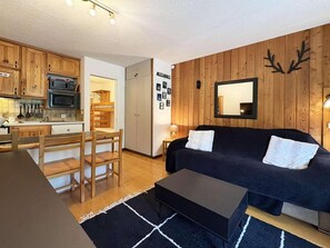 A compact living space with a kitchenette, a dining area, and a sofa.